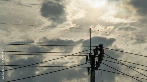 Konstfotografi Electrician worker climbing electric power pole to repair the damaged power cable line problems after the storm