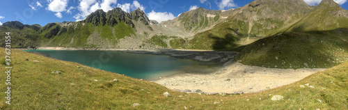 Fototapeta Naklejka Na Ścianę i Meble -  Panoramic view of an alpine lake between the rocks.