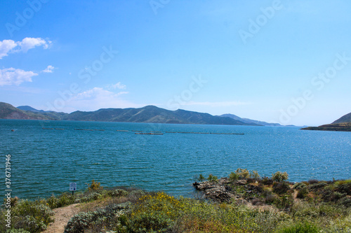 gorgeous shot of the deep blue water and lush green mountains ranges at Diamond Valley Lake in Hemet California photo