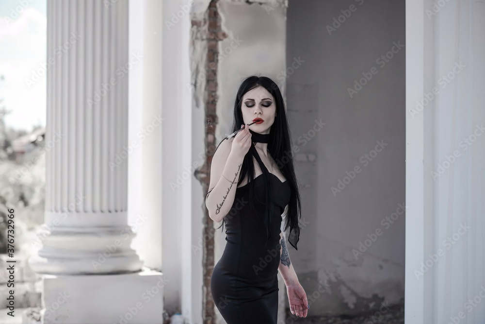 Halloween outfit for lady. Beautiful young woman in black modern dress . Halloween art design. Dark theme For Halloween Concept Halloween outfit for lady. Beautiful young woman in black modern dress . Halloween art design. Dark theme For Halloween Concept