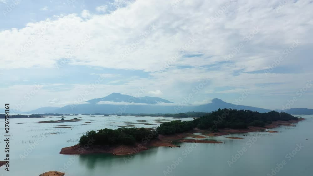 The islands on the Nam Ngum Reservoir surrounded by mountains in Asia, Laos, towards Vientiane, on a sunny day. The islands on the Nam Ngum Reservoir surrounded by mountains in Asia, Laos, towards Vientiane, on a sunny day.
