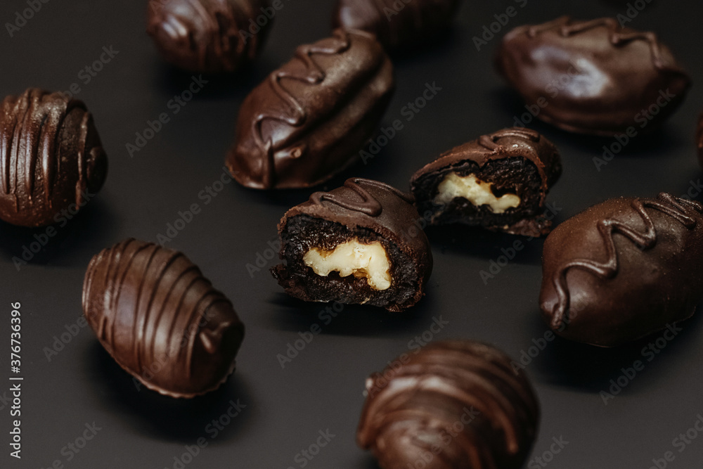 Handmade chocolates with nut inside on dark background. Handmade chocolates with nut inside on dark background.