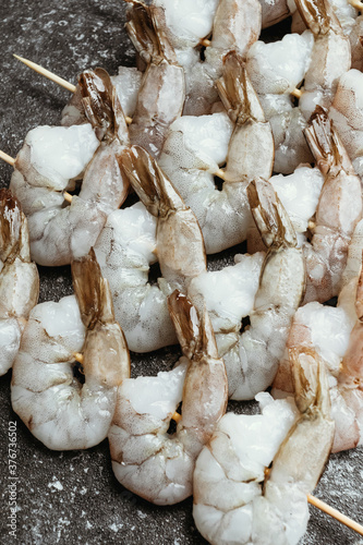 Fresh shrimps with lemon and thyme on skewers. Macro.