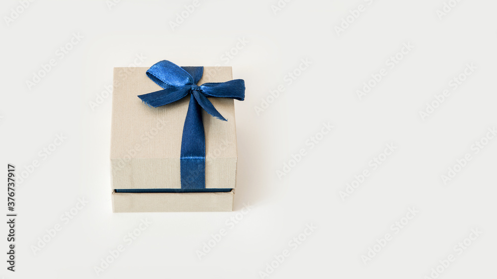 small beige gift box wrapped with blue celebration tape isolated on white background