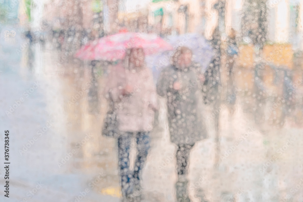 Light pastel blurred background with silhouettes of two girls, girlfriends under umbrellas on a rainy day, city life, bokeh. Concept of modern urban lifestyle. Light pastel blurred background with silhouettes of two girls, girlfriends under umbrellas on a rainy day, city life, bokeh. Concept of modern urban lifestyle.