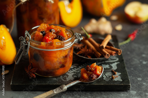 Tableau sur toile Homemade pumpkin and apple chutney with raisins in jars on a table