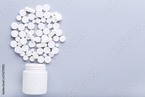 Medicine pills and bottle on grey background
