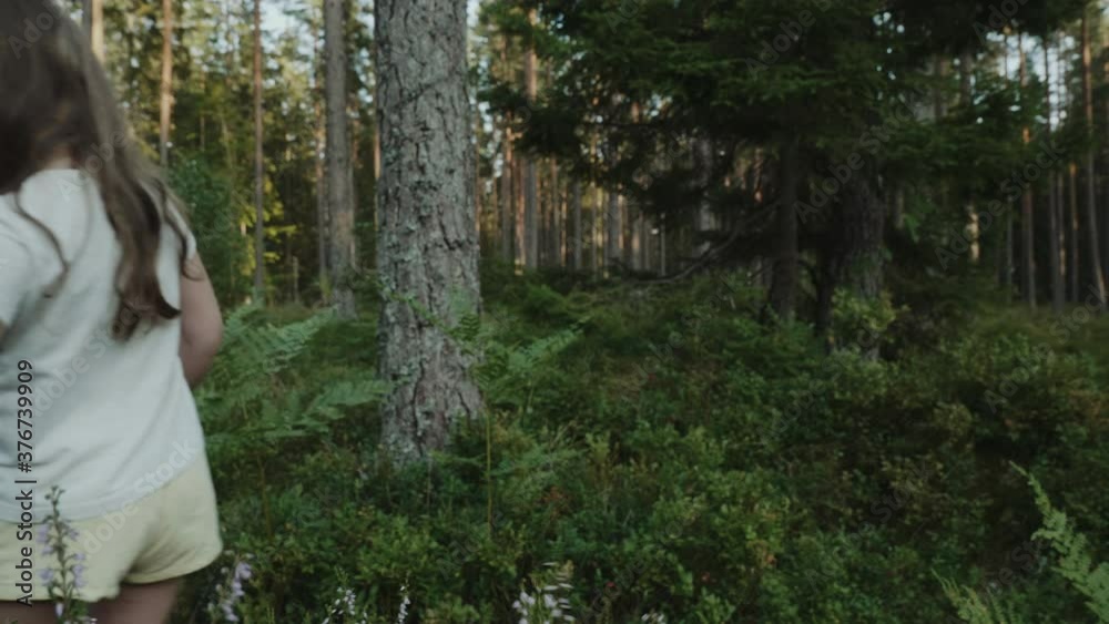 Girl walking in a deep forest all alone and touching plants with her hand Girl walking in a deep forest all alone and touching plants with her hand