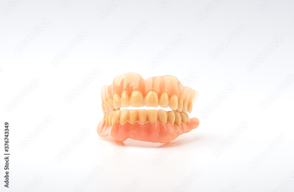 plastic full removable denture of human teeth closeup isolate on white background plastic full removable denture of human teeth closeup isolate on white background