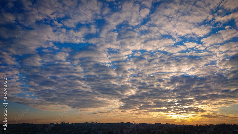 Beautiful Sunrise. The Deep Blue Sky Is Completely Covered With White Clouds.