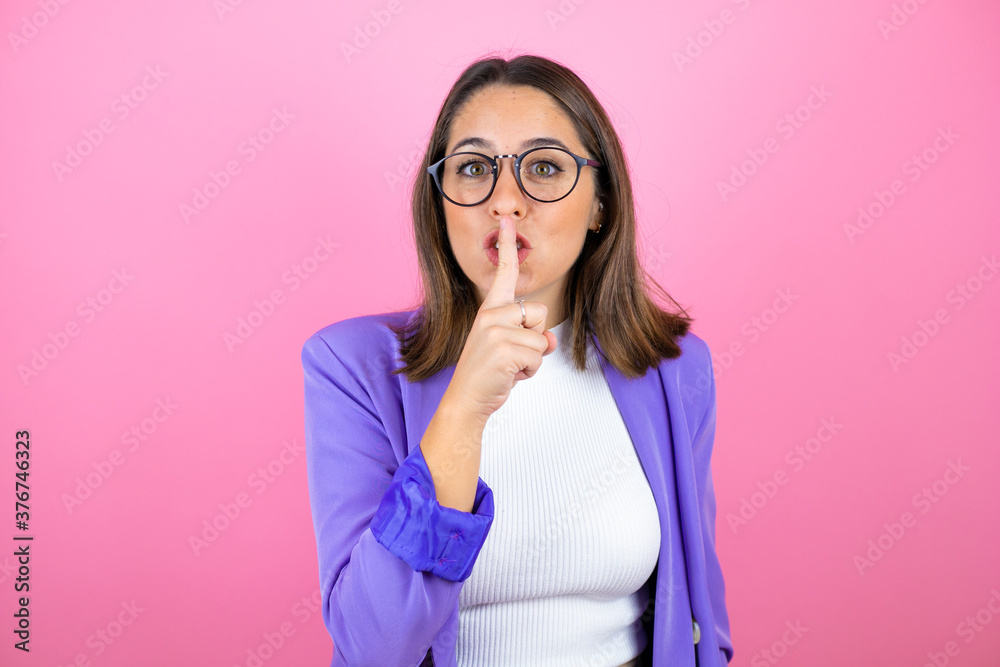 Young beautiful business woman over isolated pink background asking to be quiet with finger on lips. Silence and secret concept. Young beautiful business woman over isolated pink background asking to be quiet with finger on lips. Silence and secret concept.
