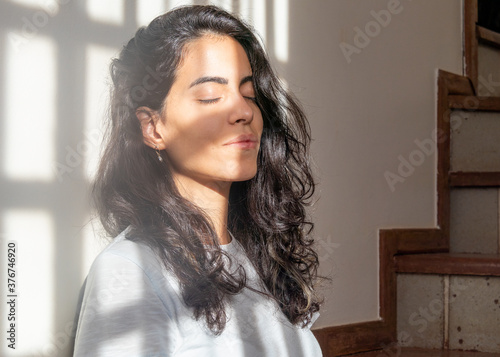 In quarantine a brunette woman takes the opportunity to sunbath inside her home in the pandemic times. Health. Stress. Solitude. Social isolation. Corona virus.