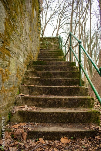 Fototapeta Naklejka Na Ścianę i Meble -  Looking up an old set of stairs with a Cobblestone Wall Next to it in a park in Suburban Pennsylvania