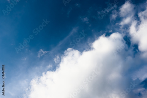 White cotton wool clouds on a sunny day. A continuous stream of clouds across the summer sky. © Mikhail