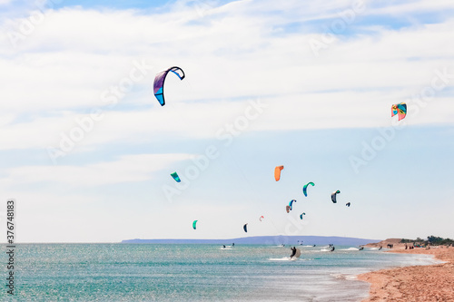 a kitesurfer surfing on the smooth azure water. recreational sport. A Man Rides A Kiteboarding In The Sea Water. extreme sport. Jump