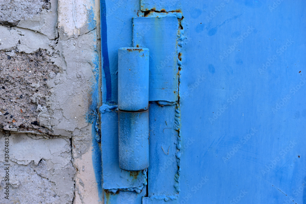 Hinged iron hinges on garage doors in blue