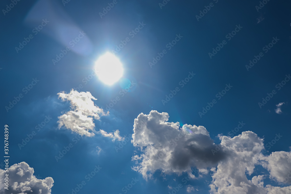 White cotton wool clouds on a sunny day. A continuous stream of clouds across the summer sky. White cotton wool clouds on a sunny day. A continuous stream of clouds across the summer sky.