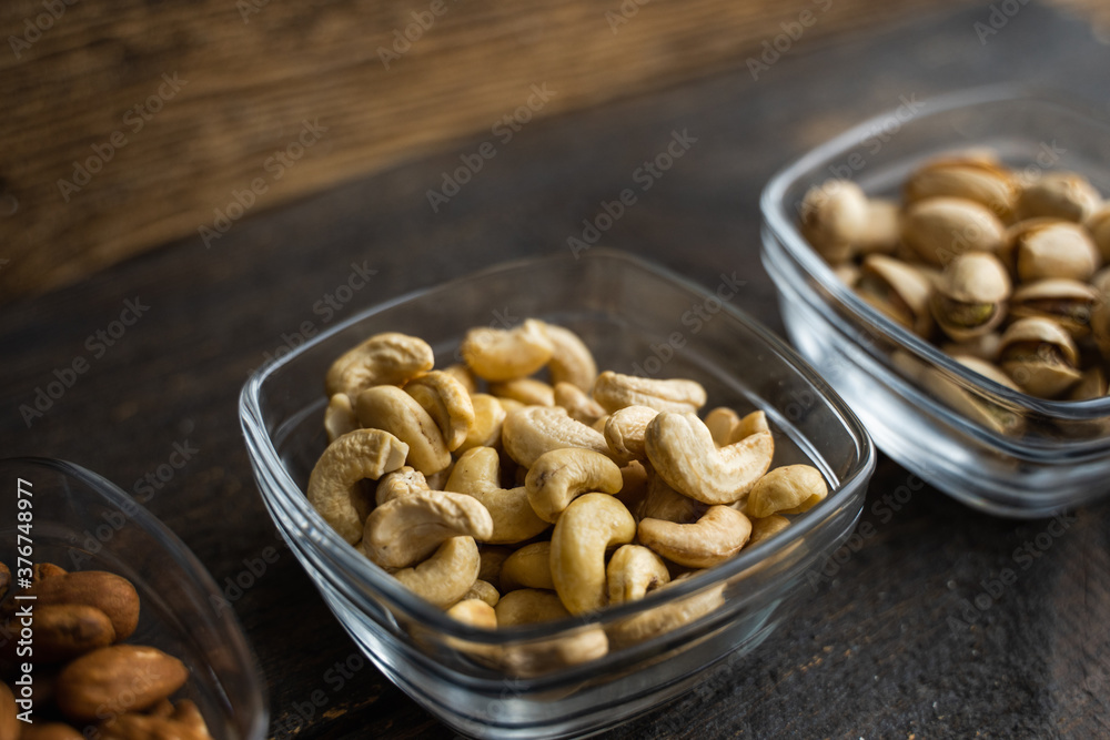 Almond, cachew and walnut in a small plates which standing on a black table. Nuts is a healthy vegetarian protein and nutritious food. Almond, cachew and walnut in a small plates which standing on a black table. Nuts is a healthy vegetarian protein and nutritious food.