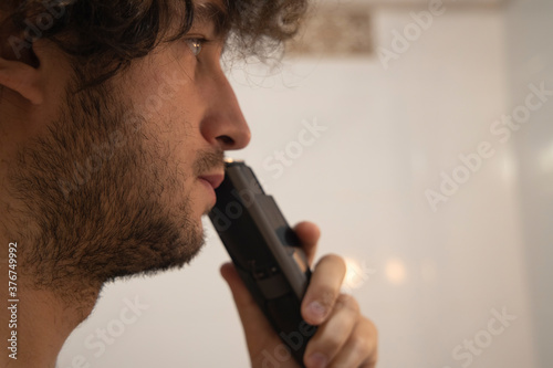 ugly ordinary man shaving process by trimmer close portrait photo