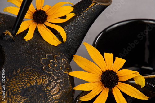 Close-up of a cast iron teapot accented with daisies. photo