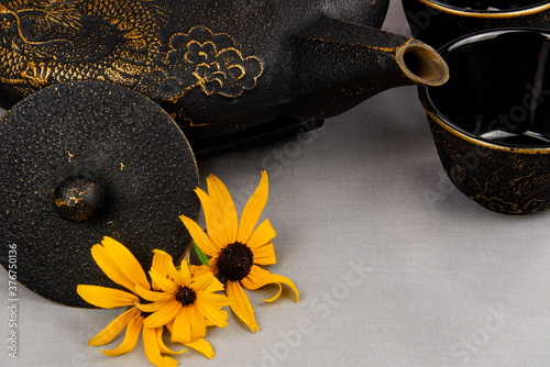 Close-up of a cast iron teapot accented with daisies. photo