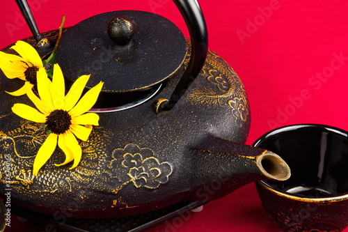 Close-up of a cast iron teapot accented with daisies. photo