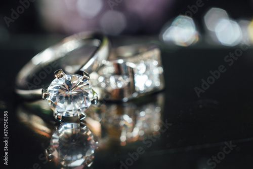 Designer wedding rings in the corner on a sparkling glitter background in panoramic banner format with copy space and selective focus
