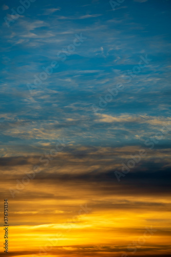 Golden and blue sky with white clouds during sunset