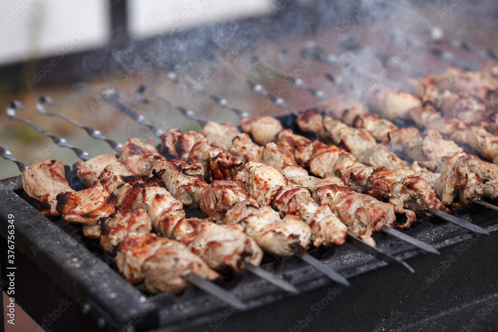 Grilled kebab cooking on metal skewer close up. Roasted meat cooked at barbecue	