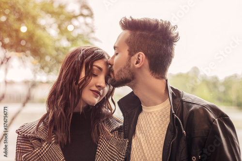 Heterosexual couple have a date and celebrate it in vegetarian restaurant. Brunette lover and curly woman hugging, kissing in silent. Romantic atmosphere, spending time together.  © Volodymyr