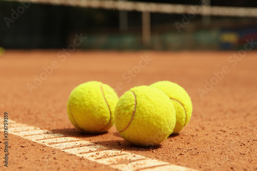 Light green tennis balls on clay court © Atlas