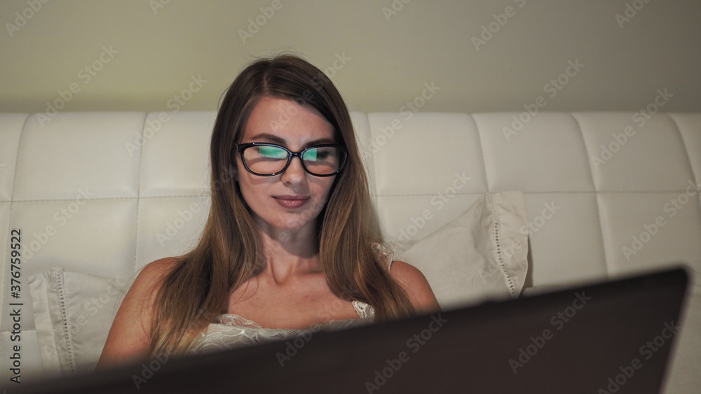 Young girl woman on the bed, distance learning for students. Coronavirus. Quarantine. Woman look at a laptop computer. Freelancer, distant work, work at home, online education Young girl woman on the bed, distance learning for students. Coronavirus. Quarantine. Woman look at a laptop computer. Freelancer, distant work, work at home, online education