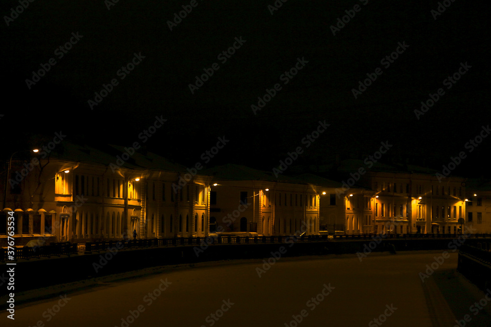 Φωτογραφία night scene: winter landscape facades of houses on the frozen river embankment i