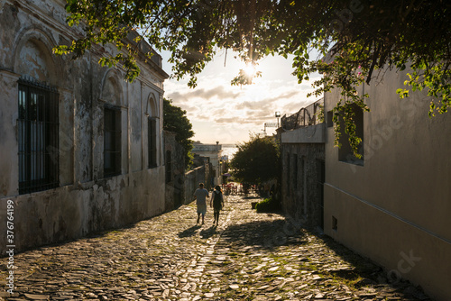 Two people strolling down cobbled street, Barrio Historico (Old Quarter), Colonia del Sacramento, Colonia, Uruguay photo