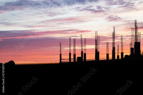 Silhouette of building structures on the background of sunset orange, violet and pink color, real estate construction, work architecture business concept