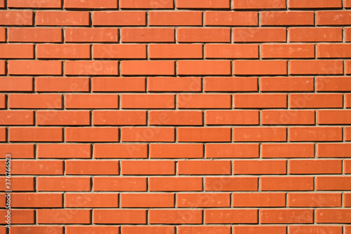 Red brick wall. Background of a new brick house. Perfect smooth brickwork.