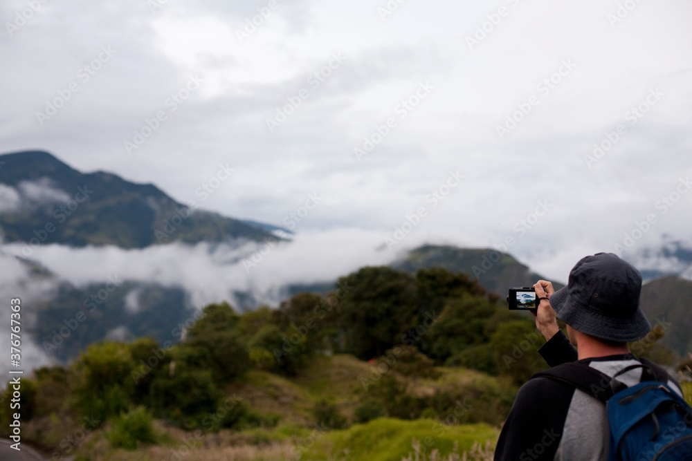 Tourist photographing distant view of the rainforest near Puyo, Ecuador Tourist photographing distant view of the rainforest near Puyo, Ecuador