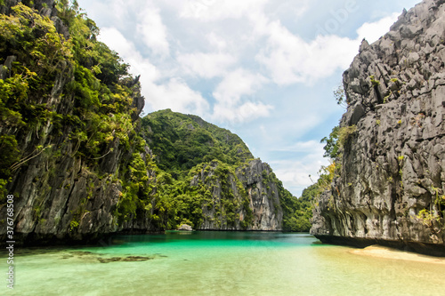 Secluded lagoon surrounded by beaches and high limestone cliffs near El Nido, Palawan, Philippines photo