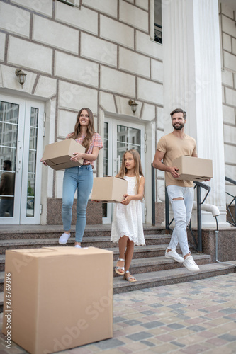Young family carrying cardboards while getting ready to move