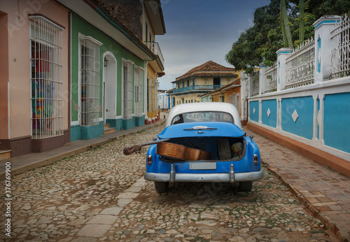 Old American car with double bass in trunk in colonial street, Trinidad, Sancti Spiritus, Cuba photo