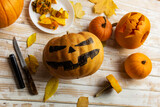 Halloween carving. Close up of pumpkins or jack-o-lantern and knife at home. Decoration and holidays concept