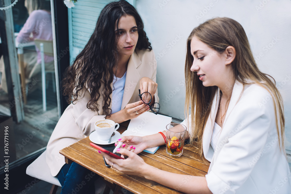 Businesswomen discussing project in outdoor cafe