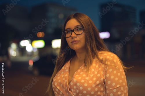 Woman in glasses and pink dress at night © Emma
