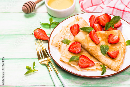 Crepes with fresh srawberries and honey. photo