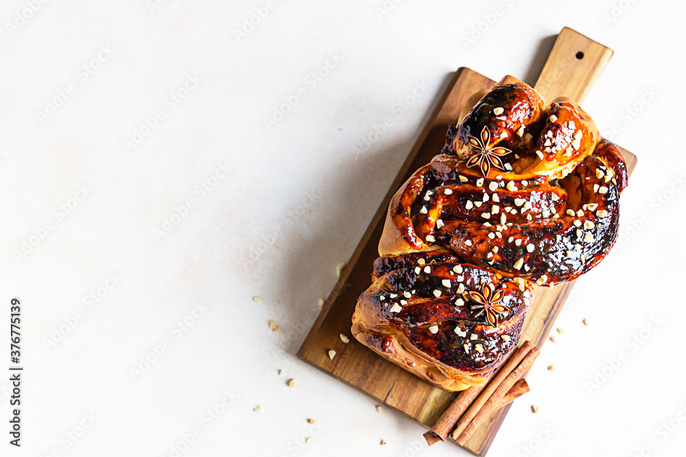 Babka or brioche bread with apricot jam and nuts. Homemade pastry for breakfast. Concrete background. Top view. Babka or brioche bread with apricot jam and nuts. Homemade pastry for breakfast. Concrete background. Top view.