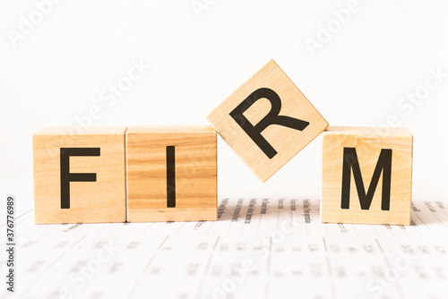 Word firm. Wooden small cubes with letters isolated on white background with copy space available