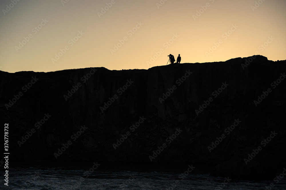 Silhouette of a photographer over a mountain.