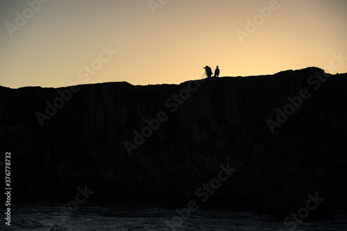 Silhouette of a photographer over a mountain.