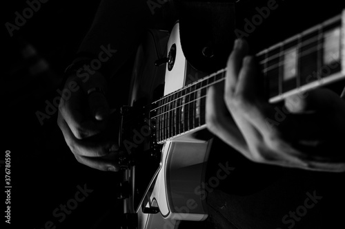 Guitarrista, guitarra sendo tocada, preto e branco, close mãos.