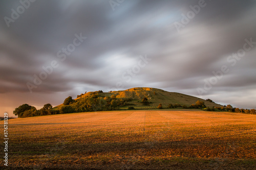 View of stormy clouds over Cley Hill during sunset photo